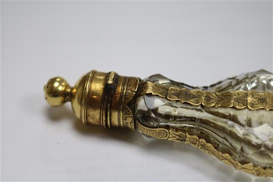 A late 18th century French yellow metal mounted glass scent bottle, with pierced removable finial.